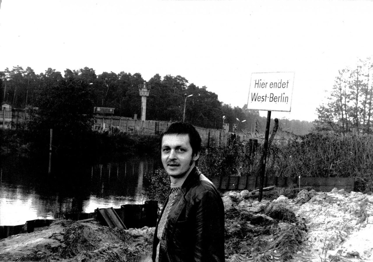 default-132 A man stands in front of the Spree river in black and white, with the Berlin wall behind him.
